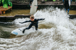 photo of a surfer navigating the Eisbach Wave which is one of many adventure activities in Munich Germany